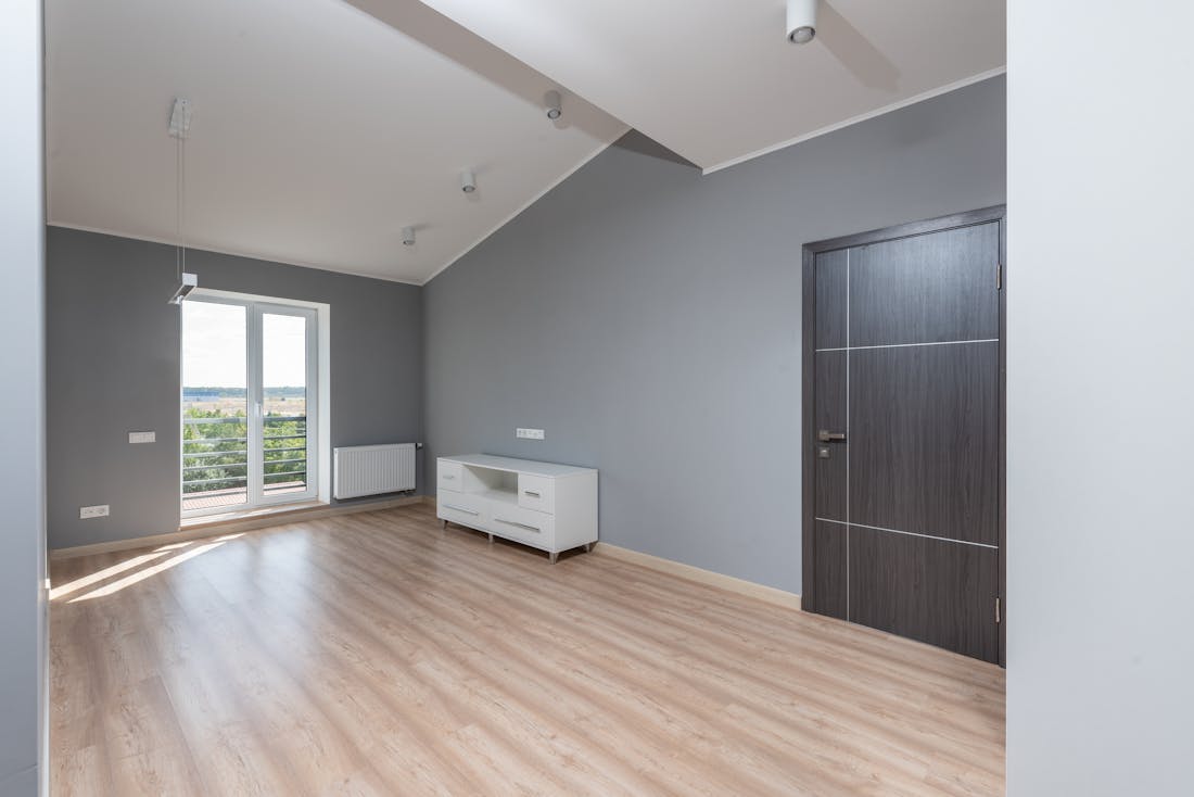 Bright, freshly cleaned empty room with wooden flooring